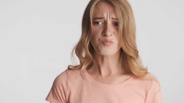 Молода Розчарована Блондинка Емоційно Жує Камеру Сірому Фоні — стокове відео