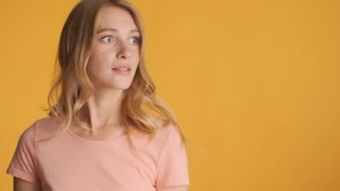 Güzel sarışın kız inanılmaz bir şekilde fotokopi odasına bakıyor ve renkli arka planda mutlu bir şekilde başparmaklarını gösteriyor.