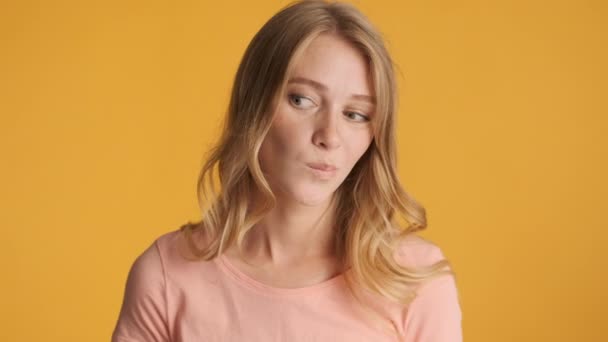 Молода Сумнівається Блондинці Розмірковуючи Над Позуванням Камеру Барвистому Фоні Потрібно — стокове відео