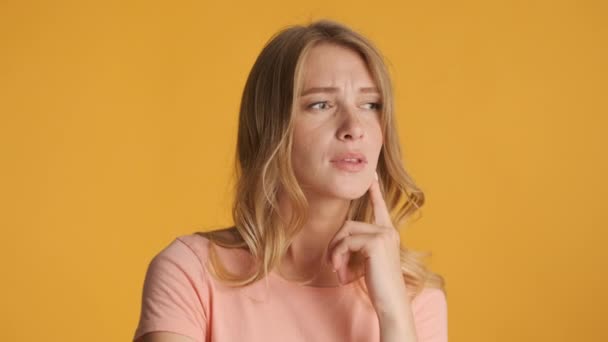 Beautiful Doubtful Blond Girl Slyly Pondering Camera Colorful Background Thinking — Stock Video