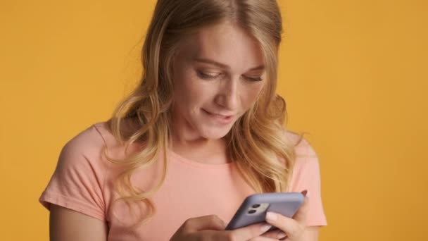 Atrakcyjny Podekscytowany Blondynka Pomocą Smartfona Niestety Pozowanie Przed Kamerą Kolorowe — Wideo stockowe