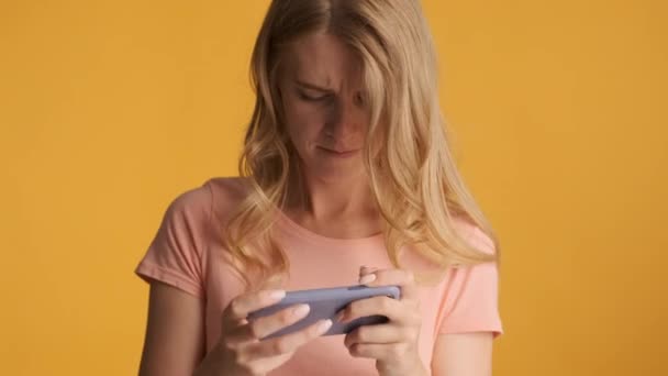 Giovane Donna Bionda Concentrata Irritabilmente Giocare Nel Gioco Smartphone Sfondo — Video Stock