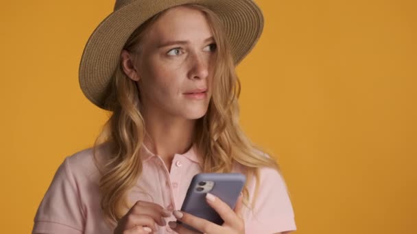 Menina Loira Atraente Chapéu Cuidadosamente Usando Smartphone Sobre Fundo Colorido — Vídeo de Stock