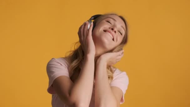 Bella Ragazza Bionda Allegra Felicemente Ascoltare Musica Cuffie Sfondo Colorato — Video Stock