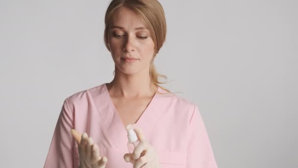 Atractiva Doctora Guantes Médicos Usando Antiséptico Cámara Sobre Fondo Gris — Vídeo de stock