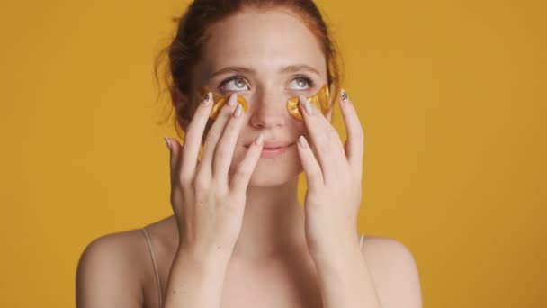 Güzel Gülümseyen Bir Kız Altın Göz Bantları Yapıştırıyor Renkli Arka — Stok video