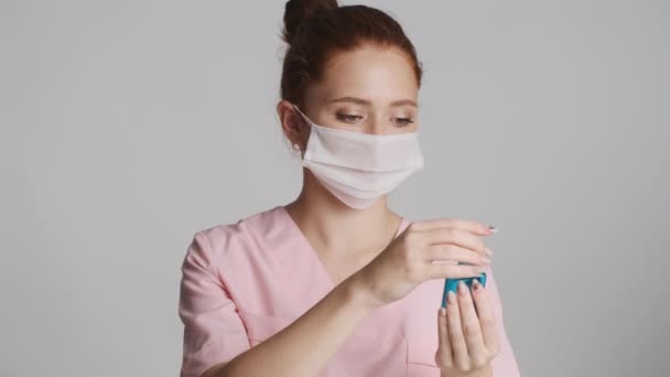 若いです女性医師で医療用マスク洗浄手とともに防腐カメラ上のグレーの背景 — ストック動画