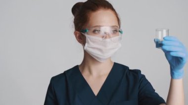 Koruyucu gözlüklü, maskeli ve tıbbi eldivenli profesyonel bir kadın doktor.