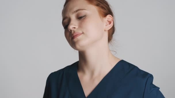 若いです魅力的な疲れ女性医師ありますマッサージ感じ痛みで首上の白い背景 — ストック動画