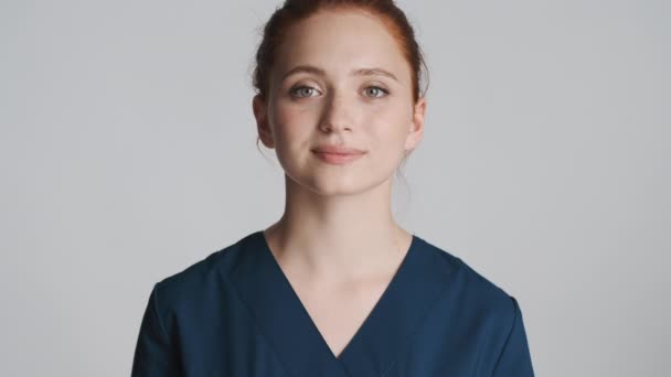 Junge Schöne Krankenschwester Schaut Glücklich Die Kamera Über Weißem Hintergrund — Stockvideo