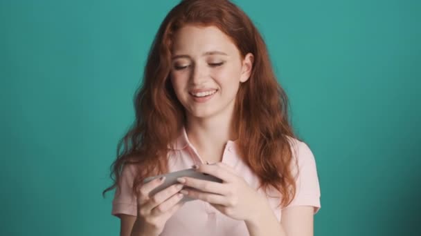 Bella Rossa Ragazza Emotivamente Giocando Gioco Smartphone Sfondo Colorato — Video Stock