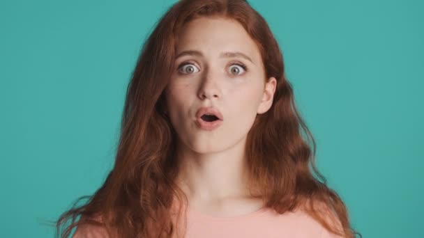 Çekici Kızıl Saçlı Kızın Mavi Arka Plandan Etrafa Baktığını Görünce — Stok video