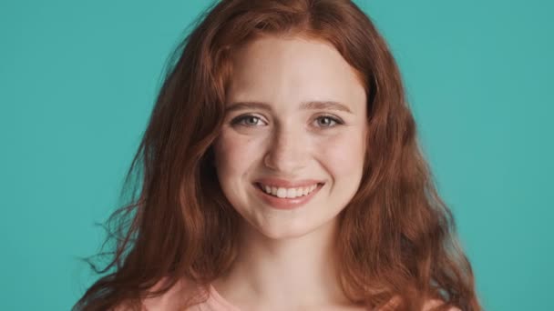 Закройте Красивую Улыбчивую Рыжеволосую Девушку Счастливо Смотрящую Камеру Цветном Фоне — стоковое видео
