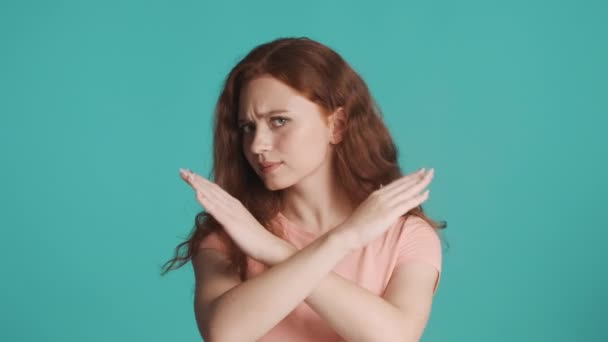 Ciddi Kızıl Saçlı Kız Mavi Arka Planda Çapraz Elleri Olan — Stok video
