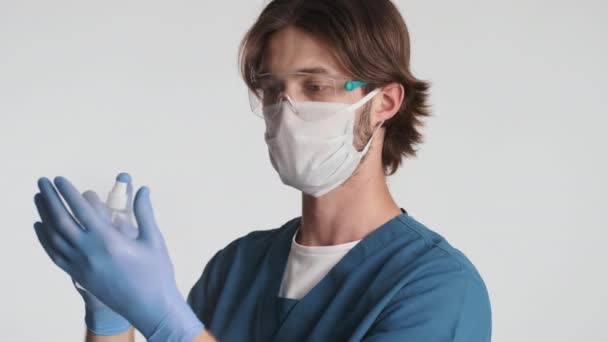 保護眼鏡 医療用マスクや手袋の若い魅力的な男性医師は喜んで防腐剤分離を適用します 安全コンセプト — ストック動画