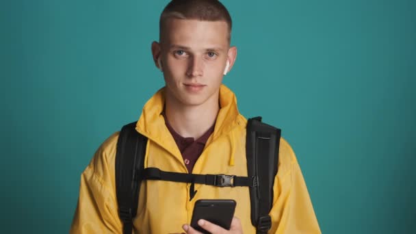 Sırt Çantalı Akıllı Telefonlu Çekici Bir Gezginin Portresi Renkli Arka — Stok video
