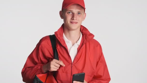 Joven Atractivo Repartidor Hombre Gorra Roja Chaqueta Con Smartphone Felizmente — Vídeos de Stock