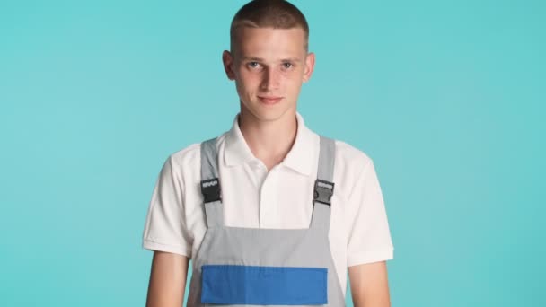 Joven Constructor Atractivo Uniforme Con Confianza Mirando Cámara Sobre Fondo — Vídeos de Stock