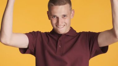 Genç, yakışıklı, heyecanlı adam renkli arka planda kameraya 