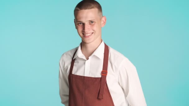 Joven Camarero Guapo Confiado Uniforme Sonriendo Cámara Sobre Fondo Azul — Vídeo de stock