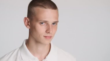 Çekici mavi gözlü adam özgüvenle fotokopi alanına ve beyaz arka planda kameraya bakıyor. Metin için boşluk