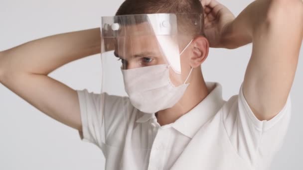 隔離された保護マスクを身に着けている医療用マスクの魅力的なカジュアル男 安全第一コンセプト — ストック動画