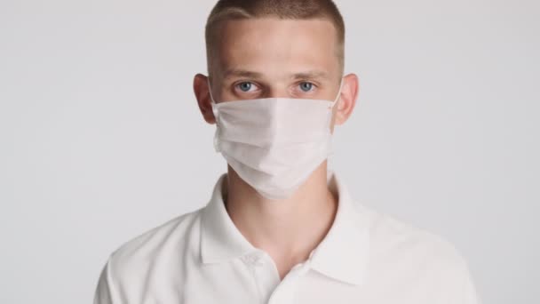 Attraktiv Casual Kille Tar Medicinsk Mask Glatt Leende Kameran Isolerad — Stockvideo