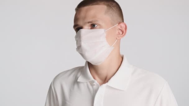 Jonge Casual Man Met Medisch Masker Bedachtzaam Rond Kijken Witte — Stockvideo