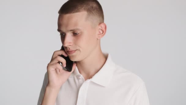 Portrét Atraktivní Ležérní Chlap Soustředěně Mluvit Telefonu Přes Bílé Pozadí — Stock video