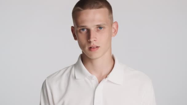 Junger Blauäugiger Mann Mit Schwenkendem Kopf Der Vor Weißem Hintergrund — Stockvideo