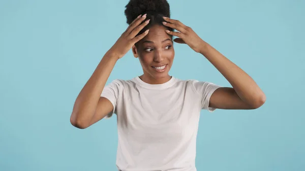 在蓝色背景下 一个疲惫的非洲裔美国女孩在镜头前情绪化地摆姿势的画像 — 图库照片