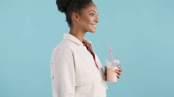美丽的非洲裔美国女孩幸福地喝着美味的奶昔 背景五彩斑斓的侧观 — 图库照片