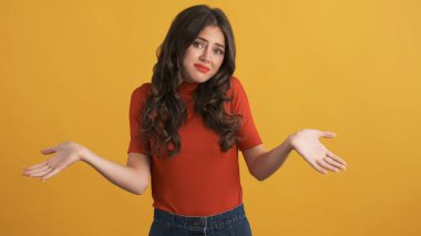 Çekici esmer kız suçlulukla ellerini kaldırıyor renkli arka planda kameraya bakıyor. İfadeyi bilmiyorum.