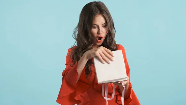 Приваблива Здивована Брюнетка Червоній Сукні Дивовижно Відкриває Маленьку Подарункову Коробку — стокове фото