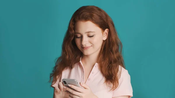Piękny Uśmiech Ruda Dziewczyna Uważnie Pomocą Smartfona Kolorowe Tło — Zdjęcie stockowe