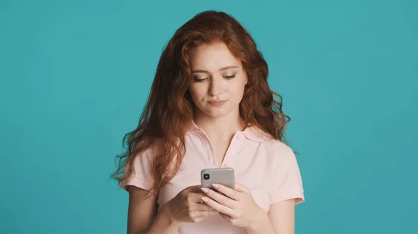 Houkutteleva Vakava Punapää Tyttö Luottavaisesti Käyttämällä Älypuhelinta Värikkäällä Taustalla — kuvapankkivalokuva