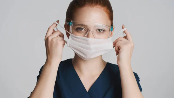 Młoda Atrakcyjna Lekarka Okularach Ochronnych Nosząca Maskę Medyczną Białym Tle — Zdjęcie stockowe