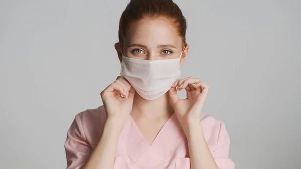 Beyaz Arka Planda Tıbbi Maske Takan Genç Bir Bayan Doktor — Stok fotoğraf