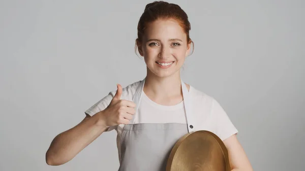Önlüklü Gülümseyen Güzel Bir Garson Kız Beyaz Arka Planda Başparmağını — Stok fotoğraf