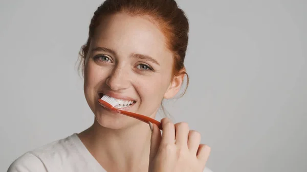 Atrakcyjne Uśmiechnięta Ruda Dziewczyna Szczęśliwie Patrząc Aparacie Mycie Zębów Białym — Zdjęcie stockowe