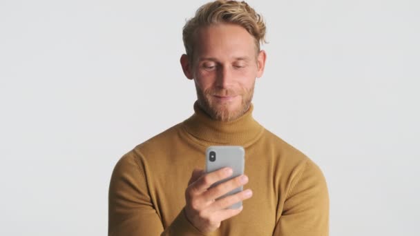 Attractive Positive Blond Bearded Man Intently Using Smartphone Smiling White — Stock Video