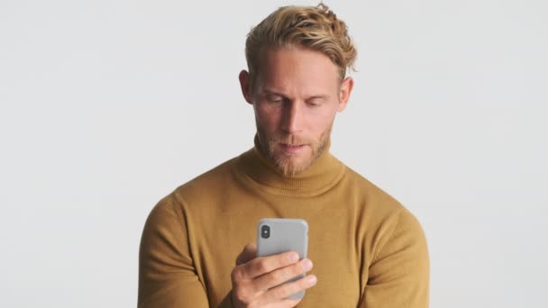 Attraktiv Allvarlig Blond Skäggig Man Med Smartphone Över Vit Bakgrund — Stockvideo