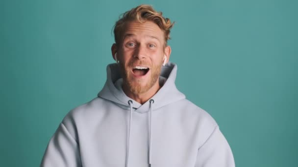 Attractive Cheerful Blond Bearded Man Hoodie Wireless Earphones Rejoicing Happily — Stock Video