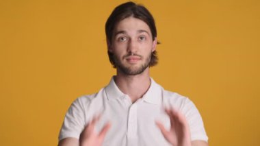 Yakışıklı, şık bir adam. Renkli arka planda saçlarını düzleştiriyor.