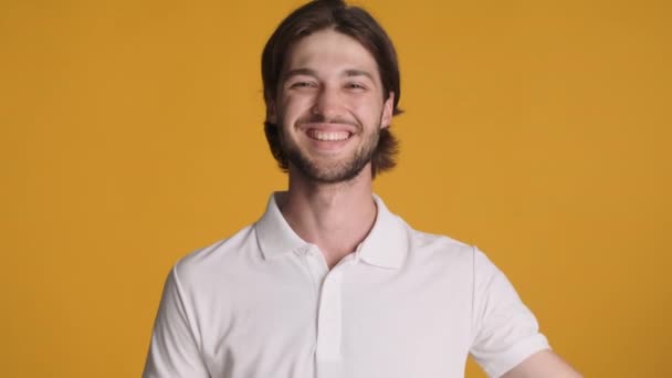 Fiatal Vidám Férfi Boldogan Integet Kamerának Narancssárga Háttér Felett Üdvözlő — Stock videók