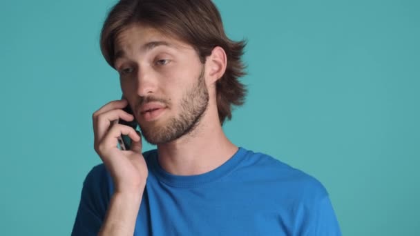 Молодой Спокойный Человек Возмущенно Разговаривает Телефону Цветном Фоне — стоковое видео