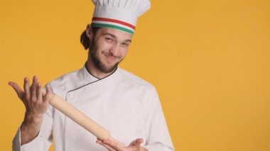 Renkli arka planda bellissimo hareketi gösteren merdaneli üniformalı profesyonel yakışıklı İtalyan şef.