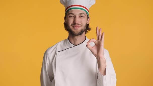 迷人的意大利职业厨师穿着制服快乐地在五颜六色的背景上表现出很好的风范 表现出色 — 图库视频影像