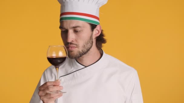 身着制服的意大利专业厨师自信地嗅着葡萄酒 在彩色背景下 在镜头前摆出了Bellissimo的姿势 Sommelier概念 — 图库视频影像