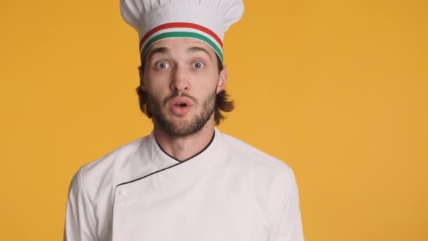 身穿制服的意大利专业厨师的画像令人惊讶地看着摄像机 露出孤立的大拇指向上的姿势 复制空间 — 图库视频影像